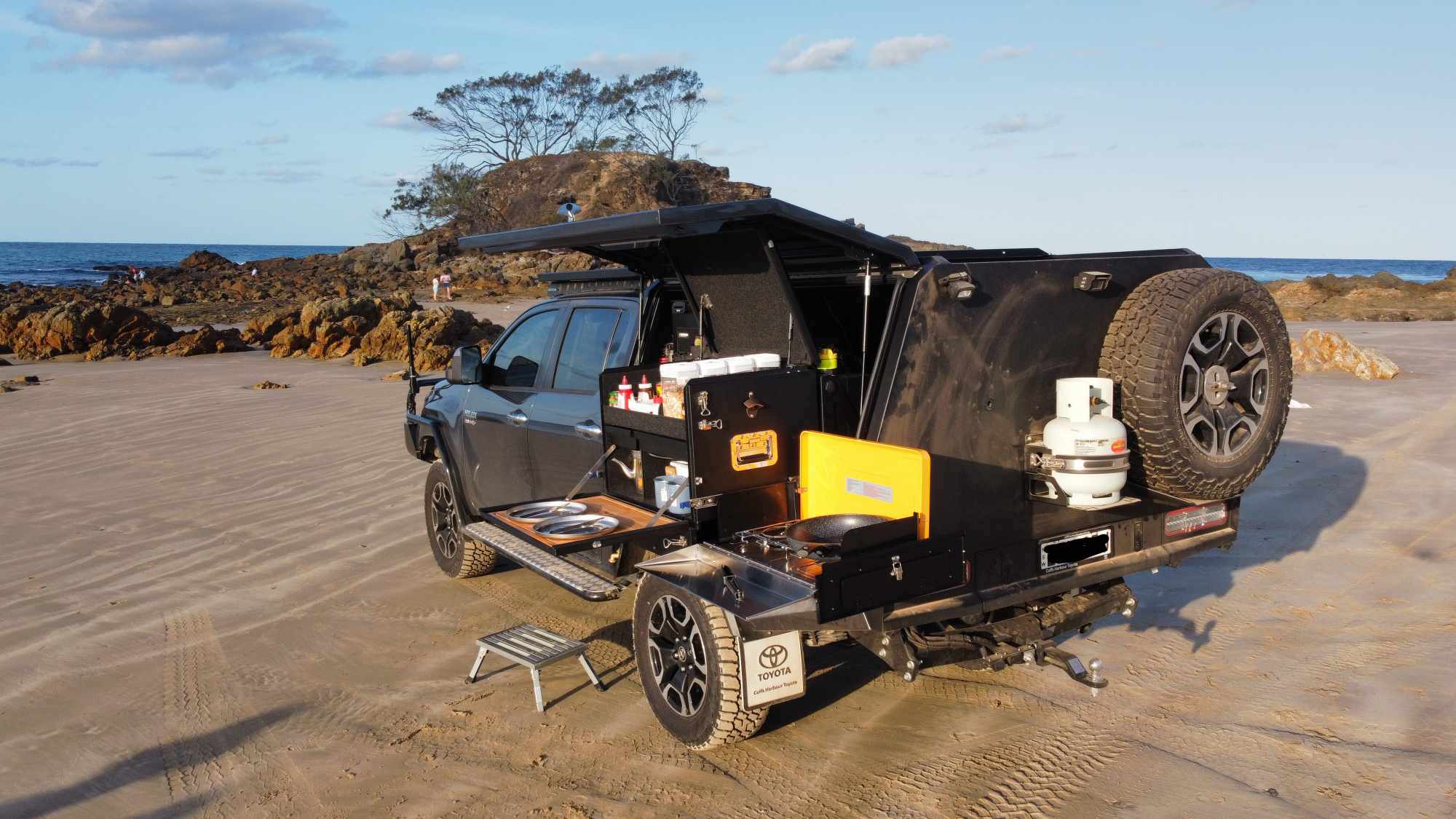 Top End Campgear Longhaul Camp Kitchen installed on the Low Mount Slide during a beach camping setup with a ute canopy.