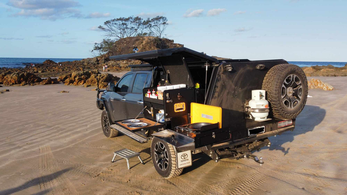Top End Campgear Longhaul Camp Kitchen installed on the Low Mount Slide during a beach camping setup with a ute canopy.